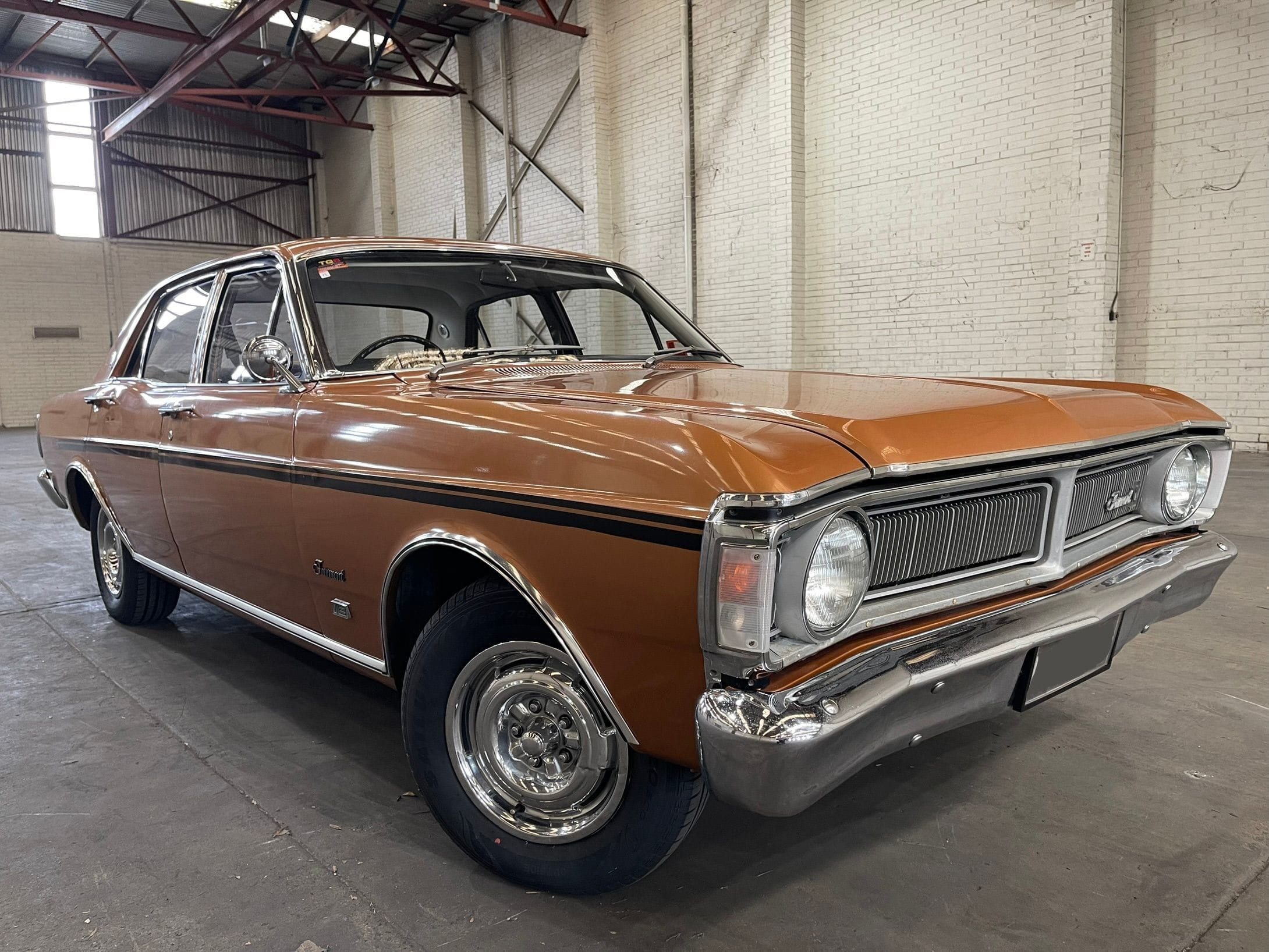 Light Brown 1970 Ford Fairmont XY GS with a black stripe on the side.