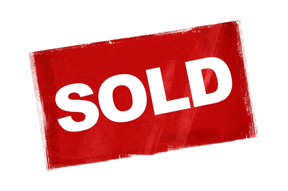 A red painted sign that says SOLD in bold white lettering.